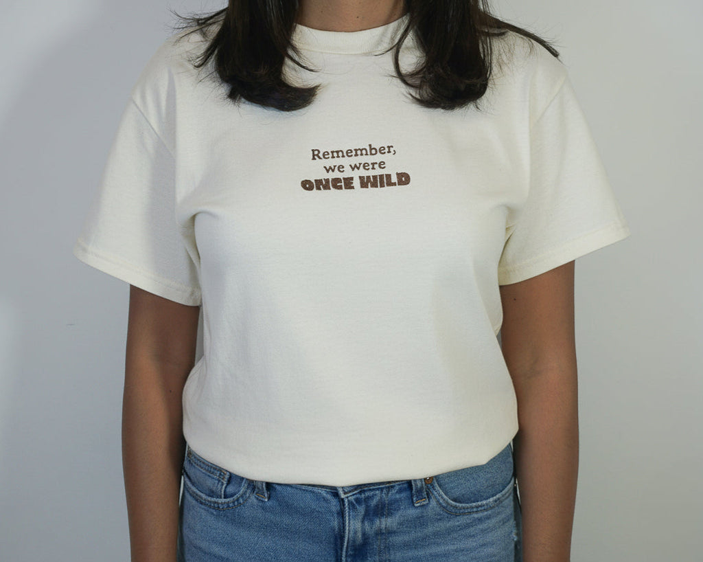 Person wearing a white t-shirt with text on a plain background